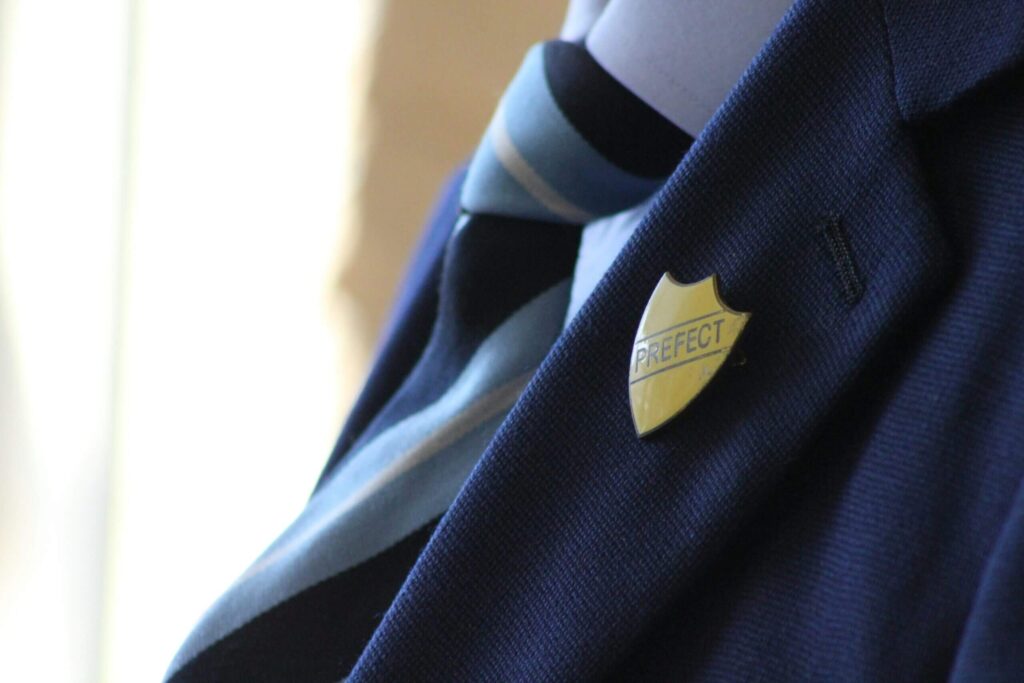 zoomed in image of a prefect badge on a school uniform